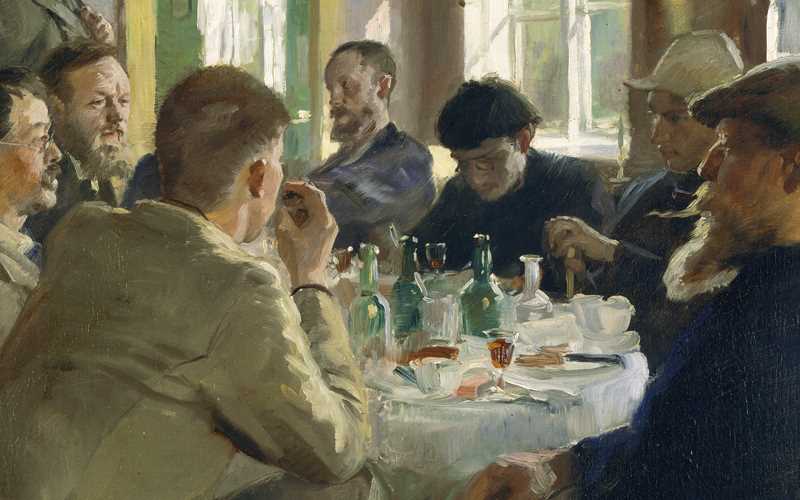 A group of men sitting at a table having a meal.